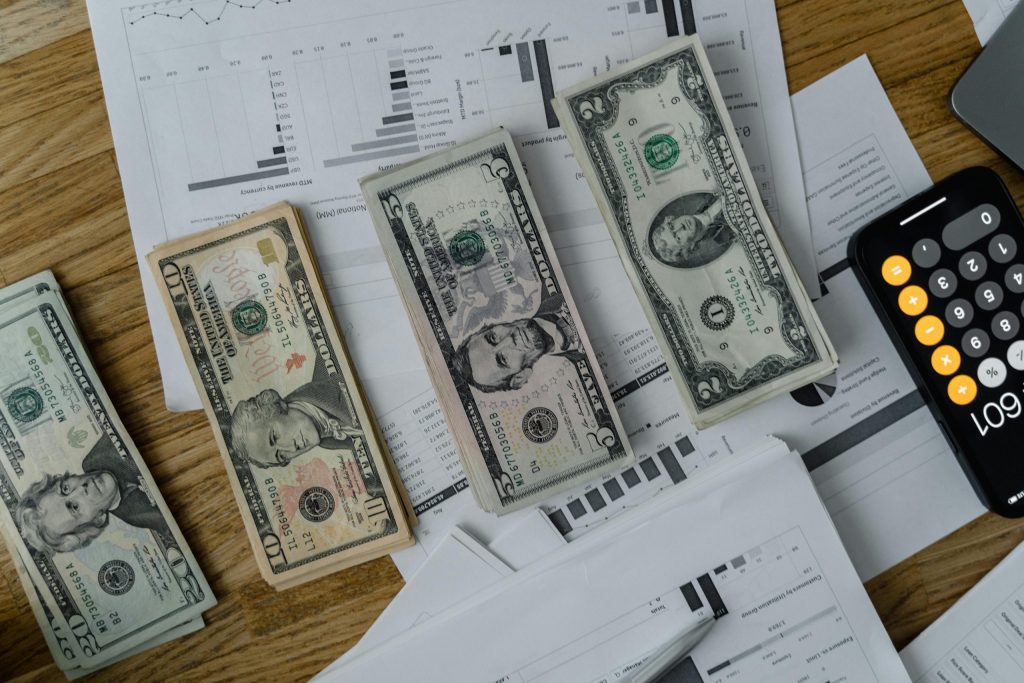 A workspace setup featuring cash, documents, and a calculator symbolizing financial analysis and budgeting.